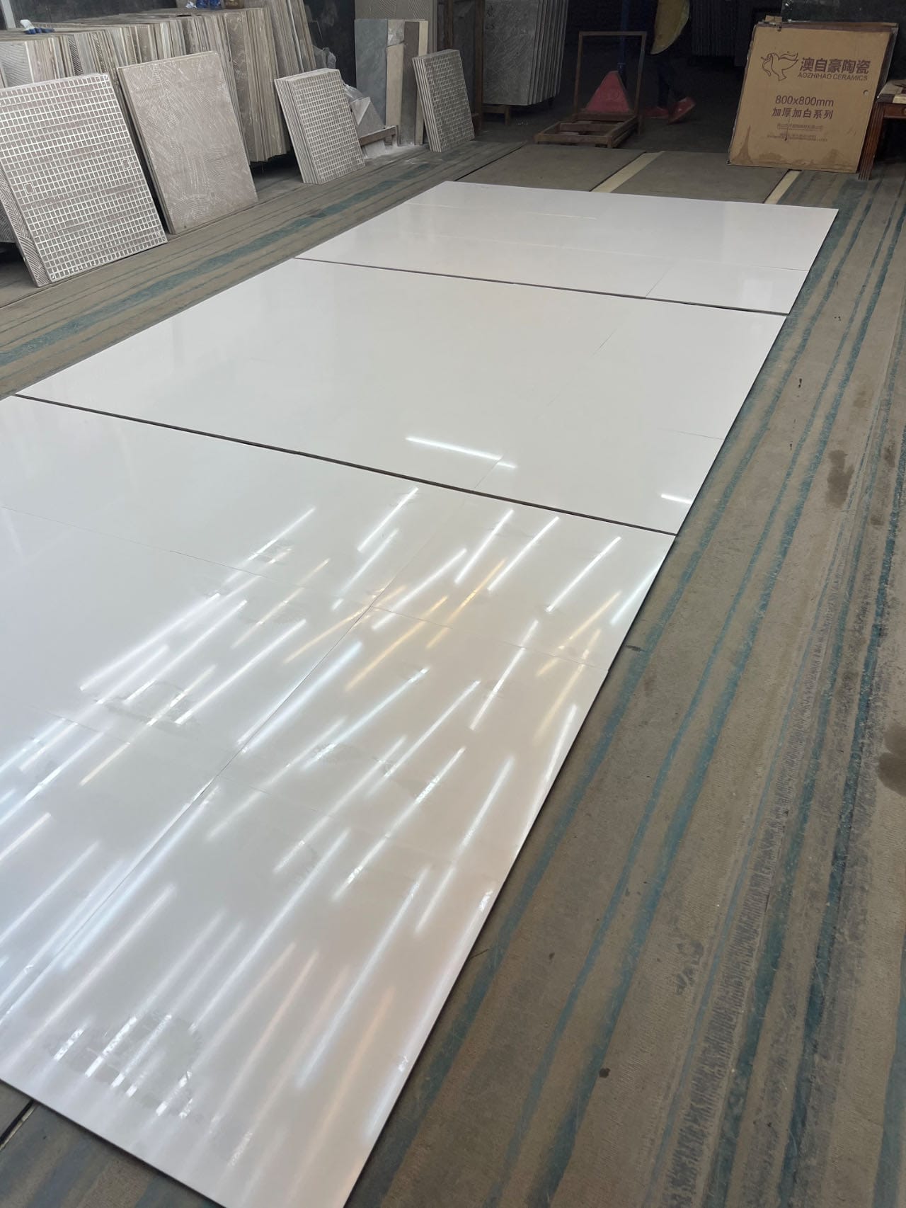 Polished white tiles laid out for inspection, glossy and smooth surface