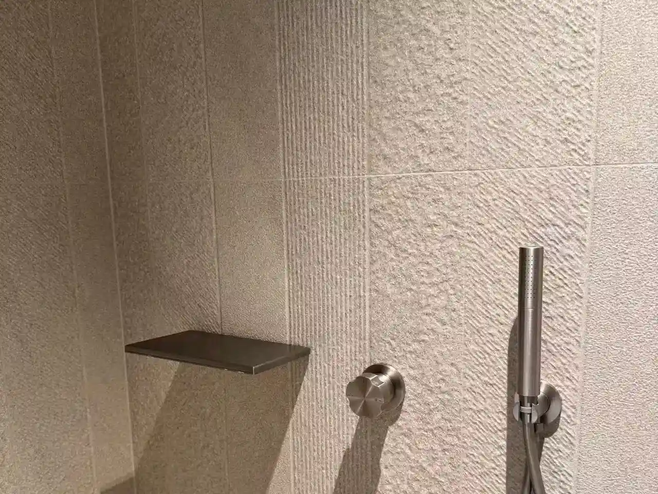 Textured china bathroom tile close-up for shower wall application with modern brushed stone-look porcelain finish