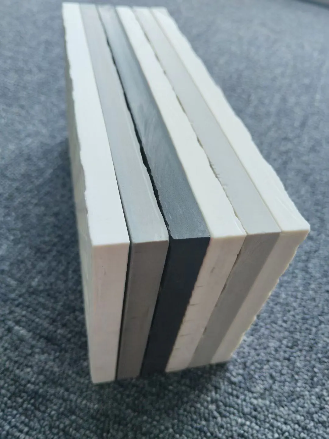Cross section of different coloured sintered stone bodies revealing through-body colour consistency