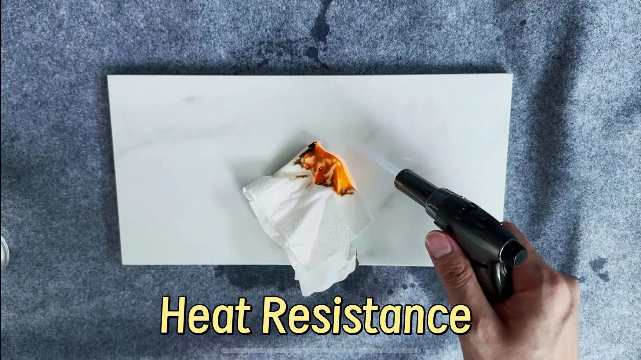 Blowtorch flame on tissue atop sintered stone panel illustrating outstanding heat resistance
