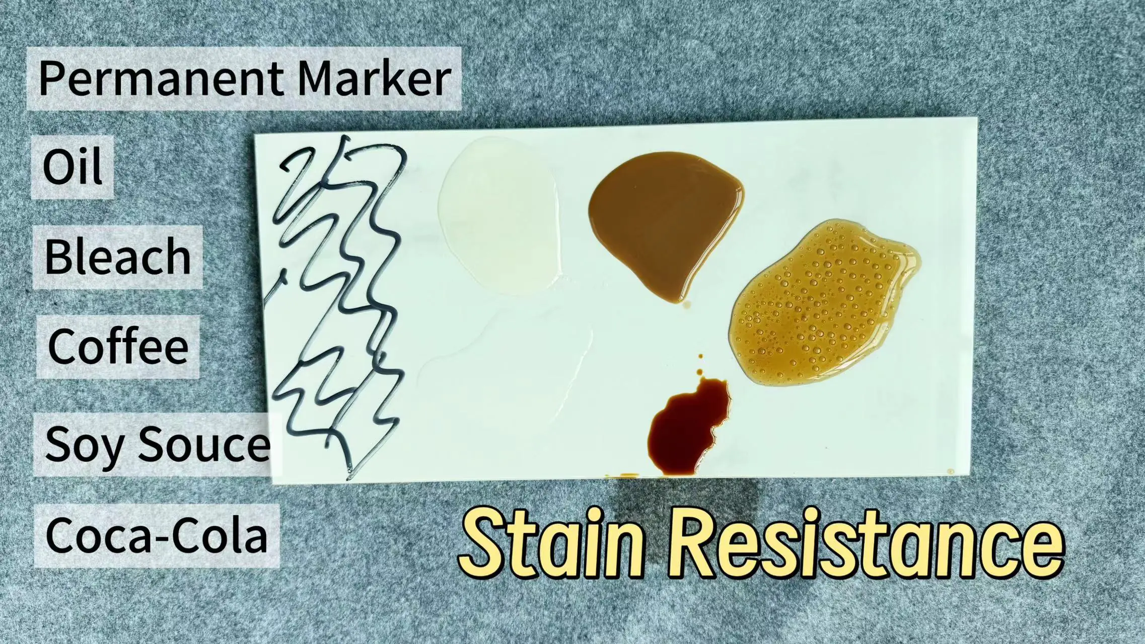 Various liquids and marker scribbles on sintered stone tile showing excellent stain resistance