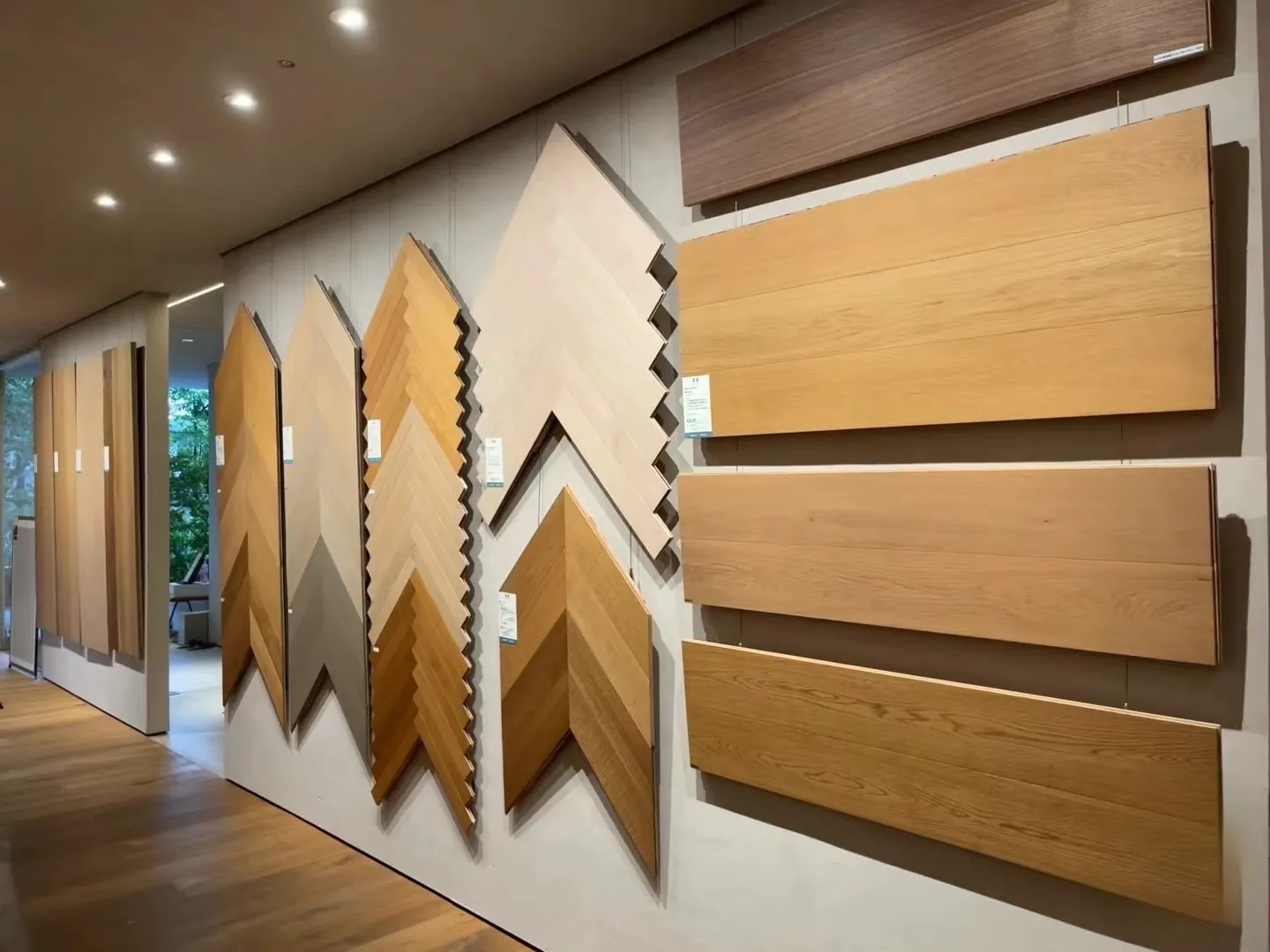 Display wall of chevron and plank wood tile samples in Kingsun China showroom for design inspiration.